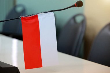 Hükümetin bayraklı ve bulanık arkaplanlı odasında önemli bir toplantı.