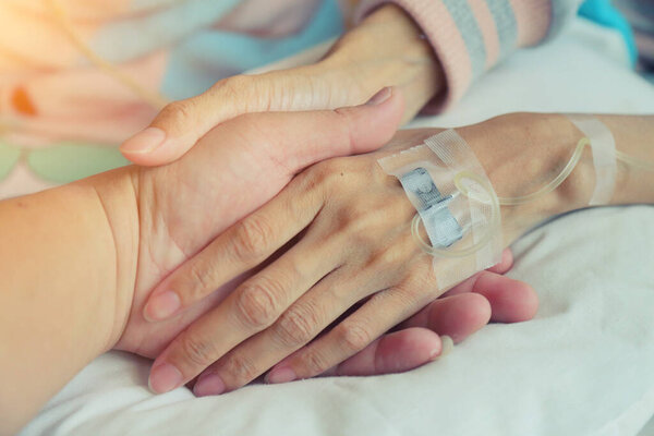 Lovers holding handswho fever patients have IV tube.