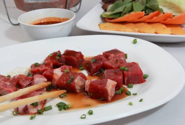 Taze çiğ et ve beyaz çadırların fotoğrafı..