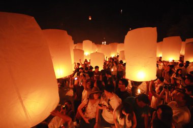 İnsanlar 24 Kasım 2012 'de Chiangmai, Tayland' da Buda 'nın eserlerine ibadet etmek için gökyüzü fenerlerini salıverirler. Bu festival her 12 dolunayda gerçekleşir..