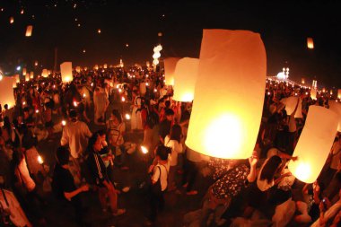 İnsanlar 24 Kasım 2012 'de Chiangmai, Tayland' da Buda 'nın eserlerine ibadet etmek için gökyüzü fenerlerini salıverirler. Bu festival her 12 dolunayda gerçekleşir..