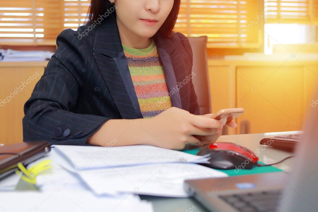 Portrait of  pretty young business woman wear glasses sitting on workplace sitting at her workplace in office with documents and with notebook, smartphone and other supplies.