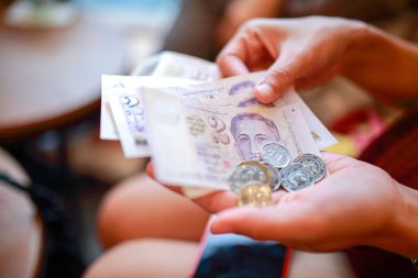 El ele tutuşan 10 Singapur dolarlık banknot alışverişe hazır, Singapur parası alışveriş için çok değerli..