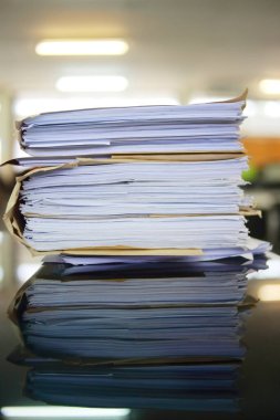 Ofis masası arşivine istiflenmiş tamamlanmamış kağıt işleri belgeleri piyasanın arşivinde inceleniyor ve gelecekte masa ofisinin ne kadar kar getireceğine karar veriliyor..