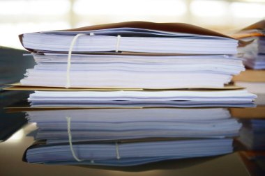 Ofis masası arşivine istiflenmiş tamamlanmamış kağıt işleri belgeleri piyasanın arşivinde inceleniyor ve gelecekte masa ofisinin ne kadar kar getireceğine karar veriliyor..