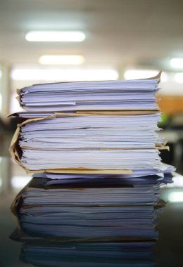 Ofis masası arşivine istiflenmiş tamamlanmamış kağıt işleri belgeleri piyasanın arşivinde inceleniyor ve gelecekte masa ofisinin ne kadar kar getireceğine karar veriliyor..