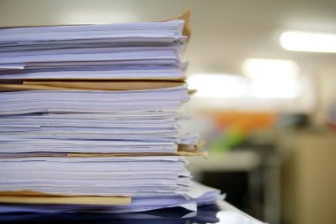 Ofis masası arşivine istiflenmiş tamamlanmamış kağıt işleri belgeleri piyasanın arşivinde inceleniyor ve gelecekte masa ofisinin ne kadar kar getireceğine karar veriliyor..