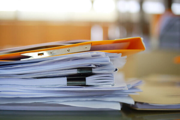 Paper business documents of unfinished stacked on office desk archive,in archive analyzing the market and considers on the size of future profits on table office.