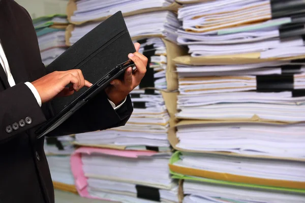 Empresário Segurando Tablet Suas Mãos Documentos Papel Empilhados Fundo Conceber — Fotografia de Stock