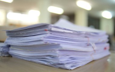 Ofis masası arşivine istiflenmiş tamamlanmamış kağıt işleri belgeleri piyasanın arşivinde inceleniyor ve gelecekte masa ofisinin ne kadar kar getireceğine karar veriliyor..