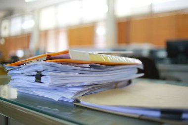Ofis masası arşivine istiflenmiş tamamlanmamış kağıt işleri belgeleri piyasanın arşivinde inceleniyor ve gelecekte masa ofisinin ne kadar kar getireceğine karar veriliyor..