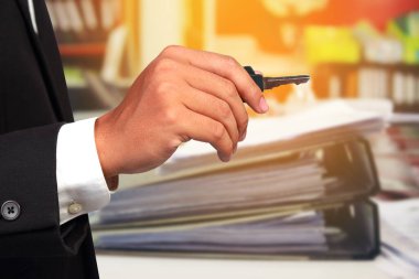 Anahtar işadamlarında ve arka planda kağıt dökümanları var. Başarıya giden yolu kavra.