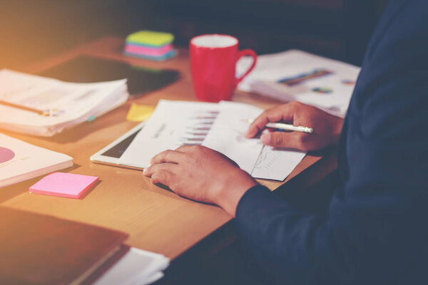 Работники офиса собирают документы о незавершенных документах на офисном столе, стопке деловой бумаги и имеют оранжевый свет
. 