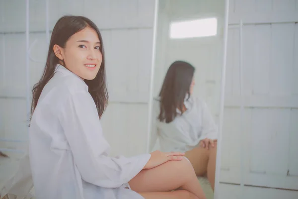 身穿白衬衫的亚洲女人靠镜摆姿势 — 图库照片