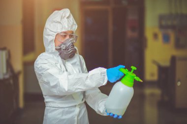 Uzman hastalık kontrolü koruyucu giysiler giyerek yeni tip Corona virüsü 2019-nCoV zatürreesini iş yerinde askıya almak ve yaymak için kimyasallar püskürtür..