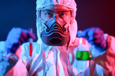 Bilim adamı laboratuarda renk tonu efekti üzerine sıvı dolu bir test tüpü tutuyor..