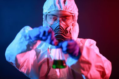 Bilim adamı laboratuarda renk tonu efekti üzerine sıvı dolu bir test tüpü tutuyor..