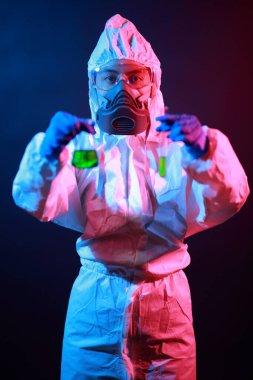 Bilim adamı laboratuarda renk tonu efekti üzerine sıvı dolu bir test tüpü tutuyor..