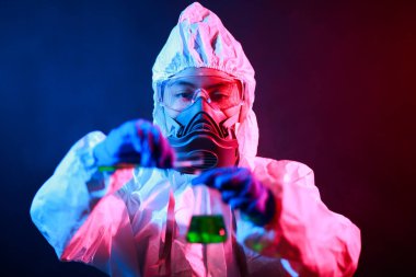 Bilim adamı laboratuarda renk tonu efekti üzerine sıvı dolu bir test tüpü tutuyor..