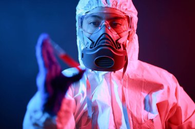 Bilim adamı laboratuarda renk tonu efekti üzerine sıvı dolu bir test tüpü tutuyor..