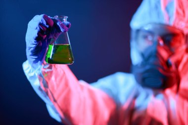 Bilim adamı laboratuarda renk tonu efekti üzerine sıvı dolu bir test tüpü tutuyor..