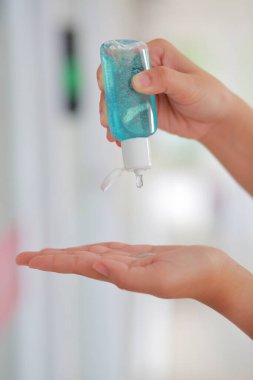 El dezenfektanı ile deriyi dezenfekte eden kadın enfeksiyonu ve Covid-19 salgınını önlüyor..