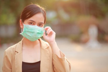 PM2.5 'u korumak için maske takan Asyalı kadın ve Covid-19 virüslü öksürük..