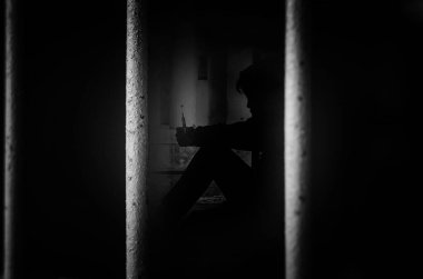 Hapisteki mahkum, kafesinde şırıngası olan adamı görüyor.  