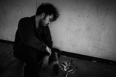 Depresyondaki Asyalı adam sigara içiyor. 
