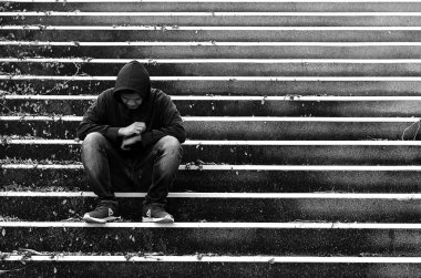 Üzgün depresif adam merdivenlerde oturuyor, siyah beyaz fotoğraf 