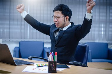 Ofiste çalışırken siyah elbiseli ve beyaz gömlekli genç Asyalı işadamı