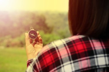 Dişi turistler seyahat için pusulaya bakıyorlar.