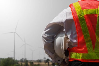 Kolunun altında şapkası olan işçi. 