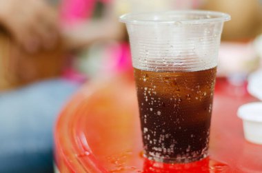 Plastik meşrubat bardağı masanın üzerine konur..