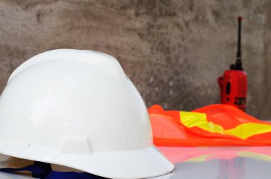 Konsept Mühendislik İnşaatı: Masada telsiz, kask ve işçi üniforması 