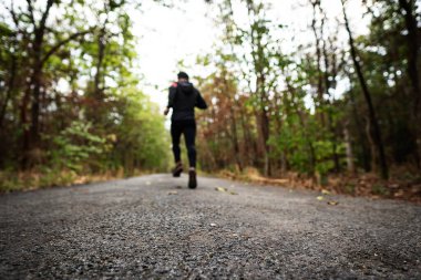 Gün batımının ılık ışığıyla parkta koşan bir koşucu