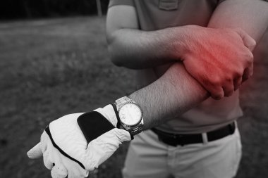 Golf sopası tutan bir golfçü ve kolunda başka bir el, kolum acıyor.