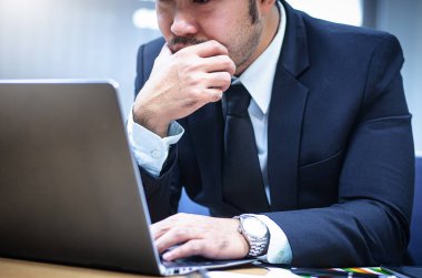 Ofiste çalışırken siyah elbiseli ve beyaz gömlekli genç Asyalı işadamı