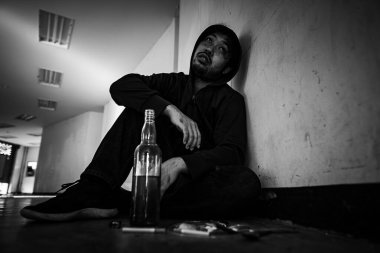 Depresyondaki Asyalı adam sigara içiyor. 