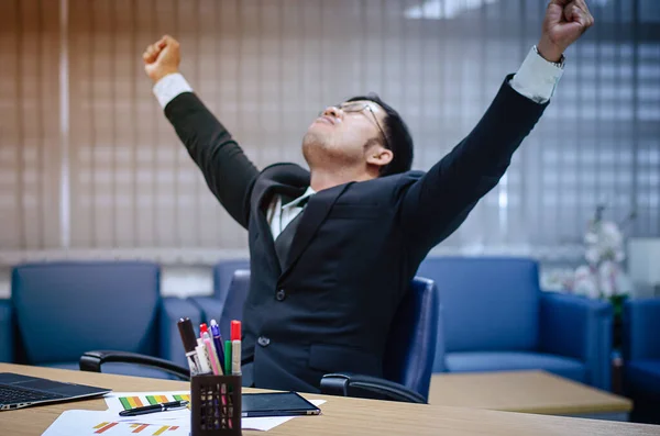 Ofiste çalışırken siyah elbiseli ve beyaz gömlekli genç Asyalı işadamı