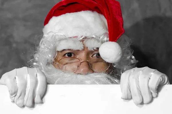Der Weihnachtsmann Hält Das Leere Laken Der Hand Grauen Hintergrund — Stockfoto