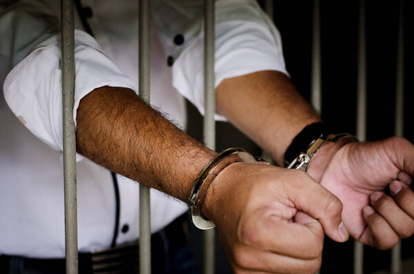 Close-up Of Businessman Hands  In Jail 