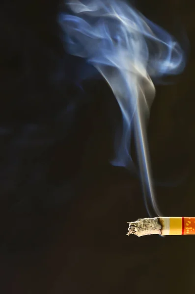 Sigarettenrook en de donkere achtergrond. Niet roken.. — Stockfoto