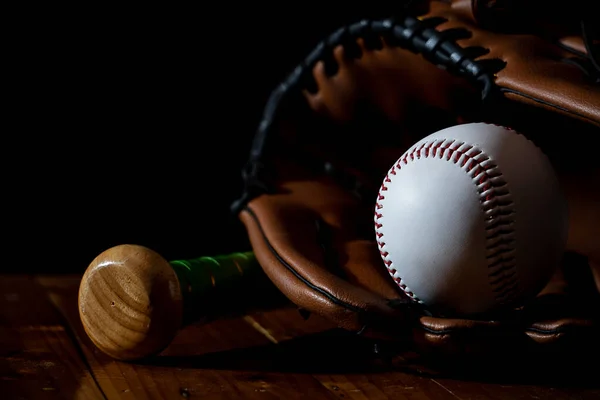 A white baseball ball and equipment with dark background