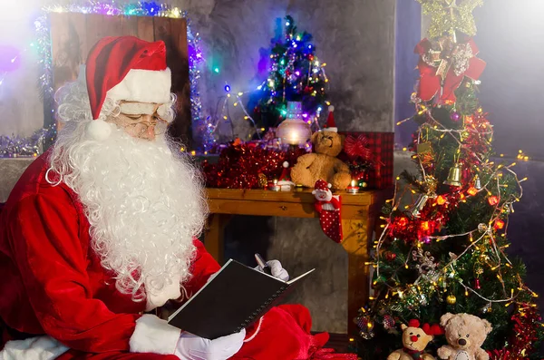 Santa Claus Sedí Židli Čte Knihu Vyzdobeným Vánočním Stromečkem Pozadí — Stock fotografie