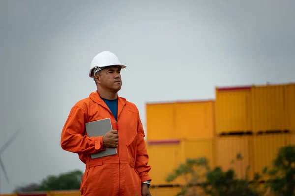engineer in uniform and helmet with the blueprint on the background of the construction site