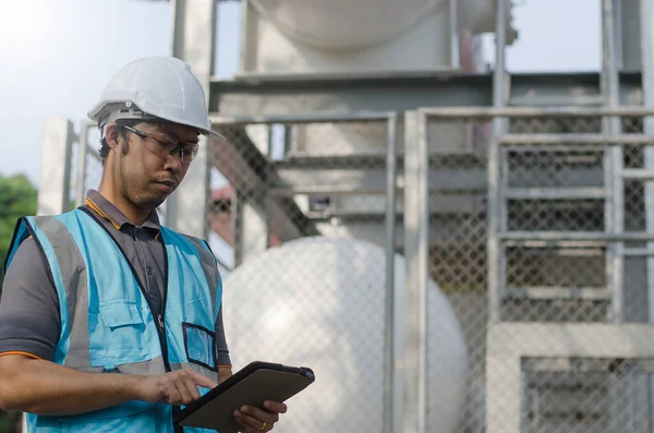 Tabletle çalışan sert şapkalı elektrikçi. 