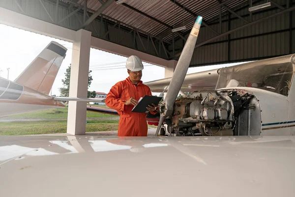 Asian male engineers were checking the availability of aircraft