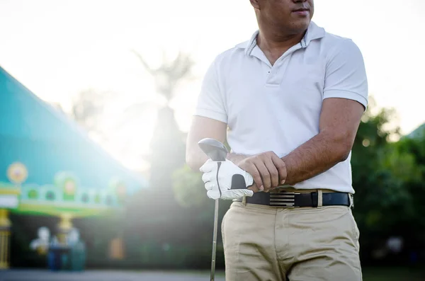 ゴルフをする前にゴルフクラブを立って保持しているゴルファーの男 — ストック写真