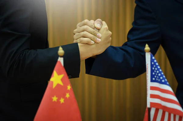 Businessmen shaking hands. USA and China flags